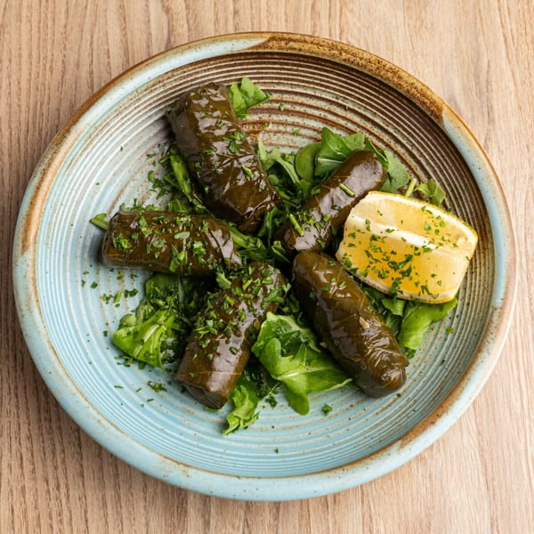 The Parthenon's dolmades, grape leaves stuffed with rice and herbs, garnished with parsley and lemon.
